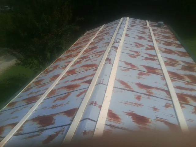 Rusted metal roof panels with new wood purlins before replacement — Storm Damage Roof Repair in Gates by Roofing Brothers