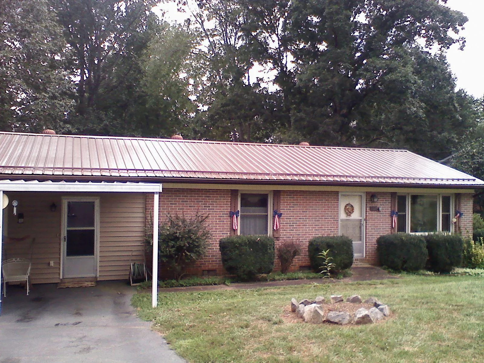 Bronze metal roof and carport on a brick ranch home — Roof Repair work by our crew in Gates